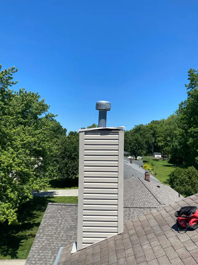 The old pale chase cover with a visibly raised edge, viewed from the roof side of the chimney chase