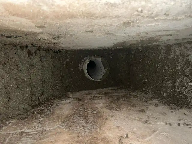 The inside of a smoke chamber photographed during an inspection, showing the flue opening and creosote-darkened masonry